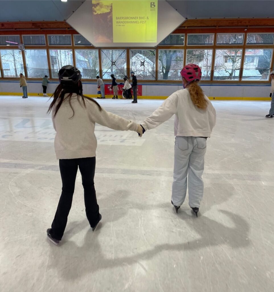 Eislaufen, Zwei Mädchen laufen Hand in Hand